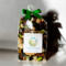 A bag of Irish Twins 'Cotton Fields' potpourri tied at the top with a green bow, casting a dark shadow on a clean, white background.